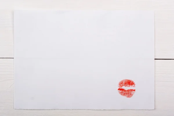 Vita pappersark med en kyss på ett vitt bord. — Stockfoto