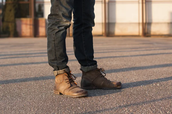 Мужские ноги в джинсах и сапогах. Хипстер на закате . — стоковое фото