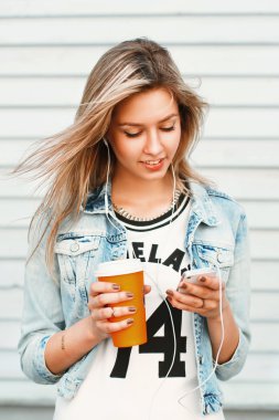 Müzik telefonu ve içme kahve güzel mutlu hippi kız dinler.