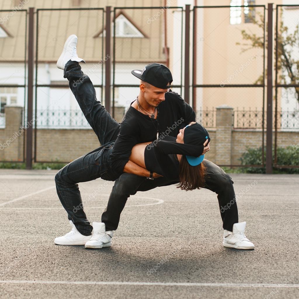 Belo jovem casal dançando hip-hop no O cara segurando a