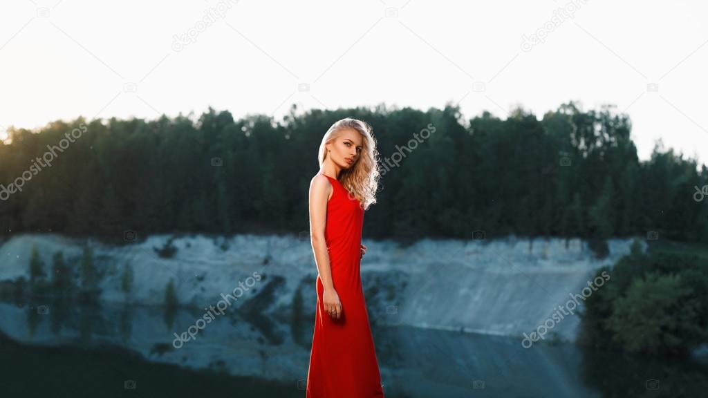 Portrait of a beautiful woman in a red dress on a mountain
