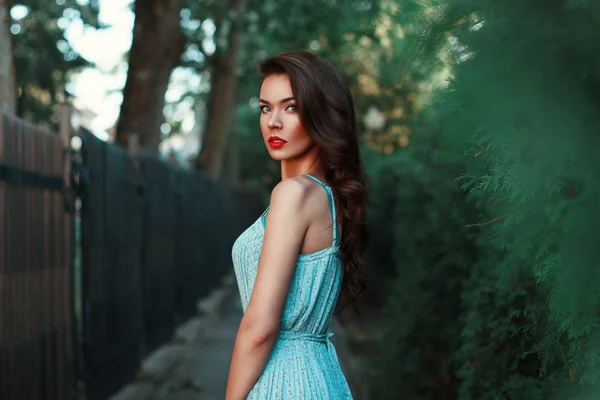 Portret van een mooi meisje in een blauwe jurk op een wandeling — Stockfoto