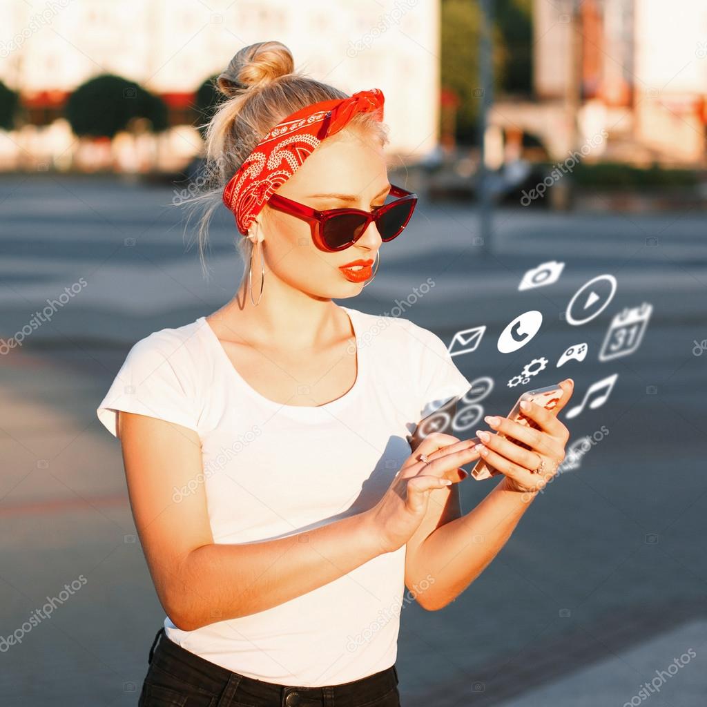 Beautiful hipster girl with sunglasses holding a phone