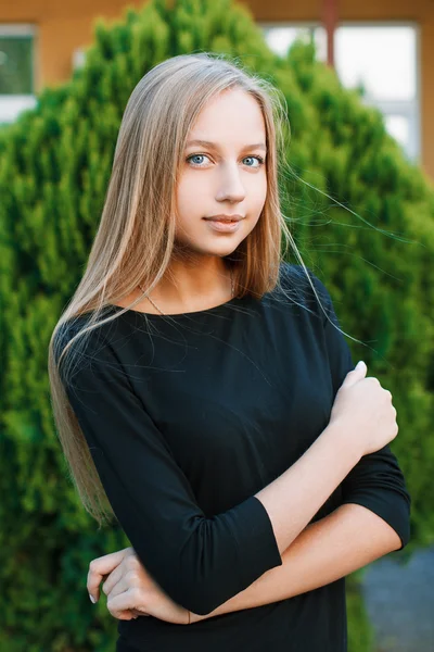 Beautiful blue-eyed woman on a background of a green bush — Stock fotografie