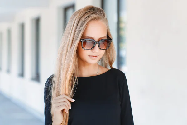 Красивая девушка в солнечных очках на фоне окон — стоковое фото