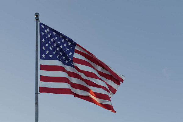 Американский флаг, развевающийся на ветру, символизирующий демократию, независимость и национальную идентичность.