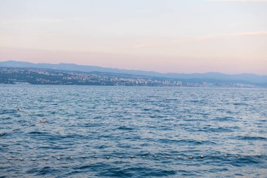 Hırvatistan 'da gün batımından sonra dalgalı deniz manzarası ve güzel gökyüzü. Yaz tatili ve dinlenme. Hırvatistan, Opatija. Yaz tatili.