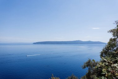 Adriyatik Denizi 'nin sakin mavi suları ve ufukta asgari bulutlarla manzarası. Mavi gökyüzü ve adaları olan güzel bir deniz manzarası. Yaz tatili