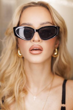 Soyunma odasındaki güzellik salonunda havalı güneş gözlüklü göz kamaştırıcı genç ve güzel sarışın kadın. Kadın moda portresi. Kozmetik ve güzellik