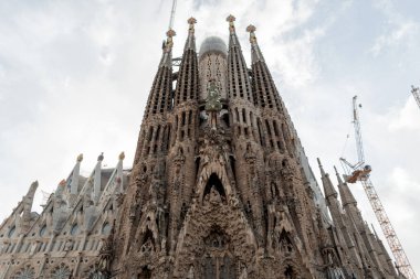 Barcelona, İspanya - 22 Kasım 2024: La Sagrada Familia katedralinin dış mimarları, Gaudi tarafından tasarlandı. 1882 'den beri inşa ediliyor. Kilise inşaatı ve vinçler Barselona seyahati