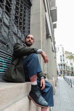 Barselona şehrinin yakınlarında oturan şık giyimli, şık İspanyol bir adam.