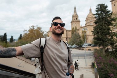 Sırt çantalı, modaya uygun güneş gözlüklü yakışıklı hippi Barselona 'da geziyor.