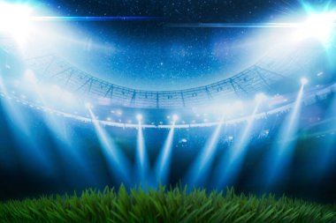 Gece büyük bir futbol stadyumunda, parlak mavi spot ışıkları altında boş yeşil çimen sahası. Dramatik ışıklandırma ile bulanık arena arka planı, spor etkinlikleri, maçlar ve turnuva temaları için mükemmel.