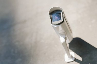 Modern açık hava beyaz güvenlik kamerası bir duvara monte edilmiş, gözetleme ve koruma sağlıyor. Kentsel ya da özel bölgelerde güvenlik, izleme ve suç önleme amaçlı yüksek teknoloji CCTV sistemi