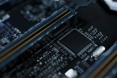 Modern bir anakart üzerinde yüksek performanslı DDR RAM modülleri ve PCIe yuvalarının makro çekimi. Fırçalanmış metal ısı lavaboları olan profesyonel bilgisayar donanımı bileşenleri, teknolojik güncelleme ve oyun geliştirme için ideal.