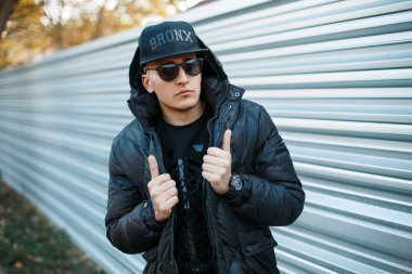 Yakışıklı olan metal duvar bir arka plan üzerinde şık siyah elbise.