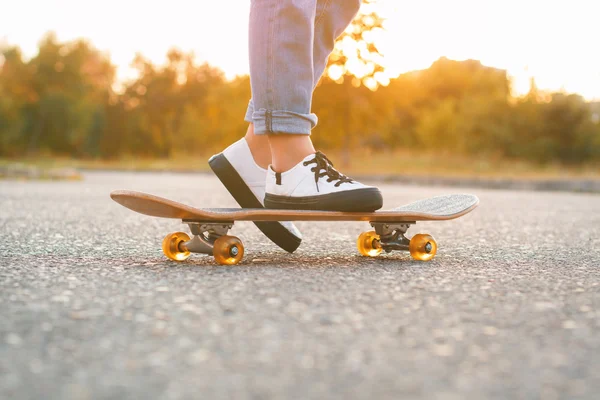 Dívka stojící na skateboardu. Detail nohy a skateboard. — Stock fotografie