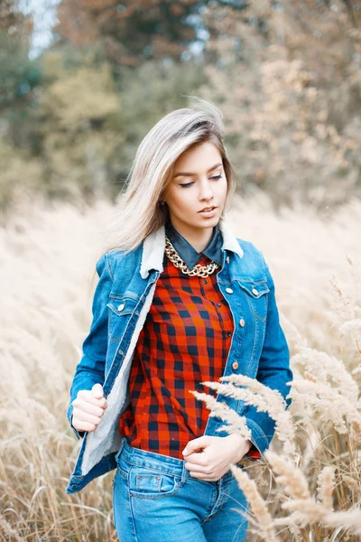Όμορφο κομψό κορίτσι στο σακάκι τζιν, καρό κόκκινο πουκάμισο και μπλε τζιν. — Φωτογραφία Αρχείου