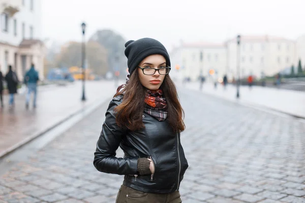 Moda look.glamor estilo de vida morena mulher modelo em jaqueta de couro preto e um chapéu de malha preto ao ar livre na rua . — Fotografia de Stock