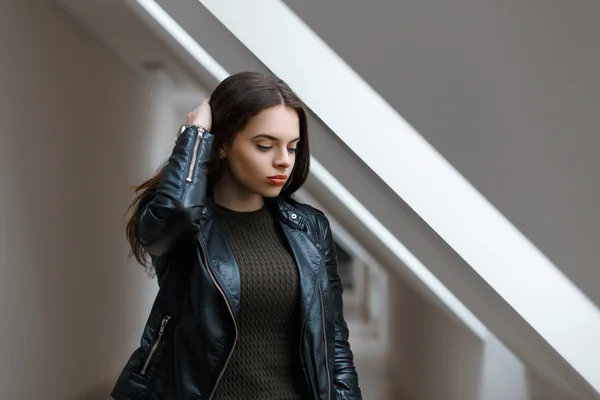 Schönes Mädchen in schwarzer Jacke in der Nähe eines Fensters im Zimmer — Stockfoto