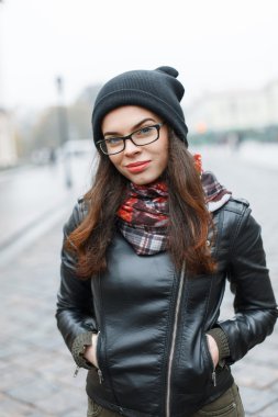 Örgü şapka, güneş gözlüğü ve deri ceket arka planı şehrin güzel kadın