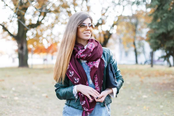 Retrato de una hermosa chica en gafas de sol, bufanda y chaqueta en el parque de otoño —  Fotos de Stock