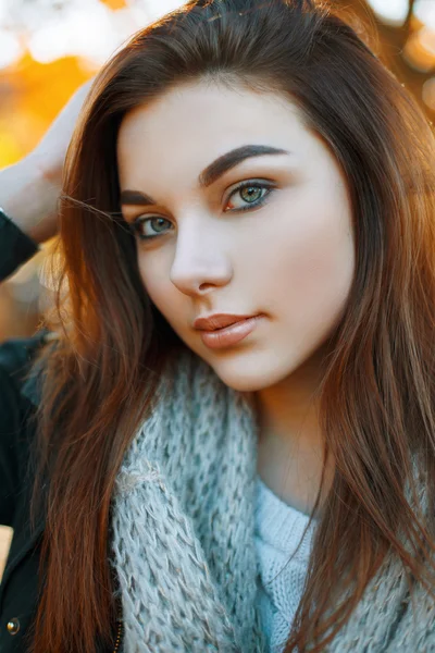 Ritratto ravvicinato di una bella ragazza in una sciarpa grigia lavorata a maglia sullo sfondo del parco autunnale — Foto Stock