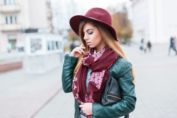 Красивая девушка в шляпе, шарфе и куртке на фоне городской суеты — стоковое фото