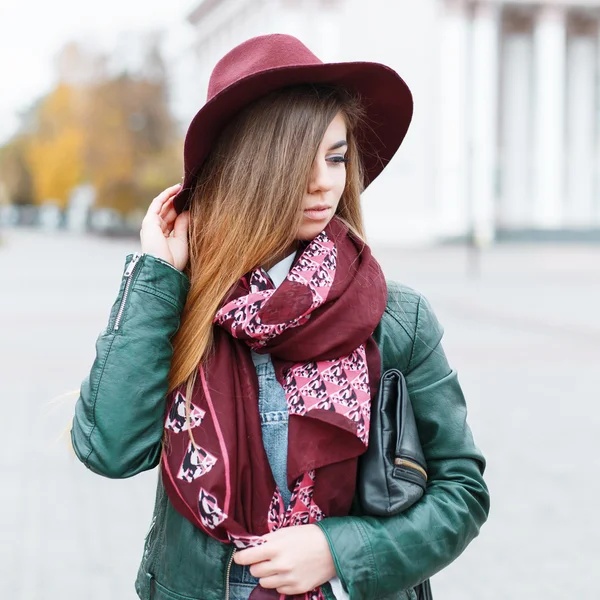 Belle fille dans un chapeau élégant et écharpe contre le bâtiment blanc — Photo