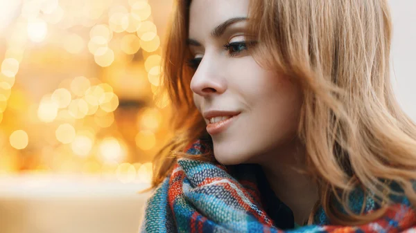 Close-up portrait of a beautiful young woman on the background of yellow lights — Zdjęcie stockowe