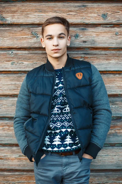 Stylish young man standing near an old wooden wall. — Stock Fotó