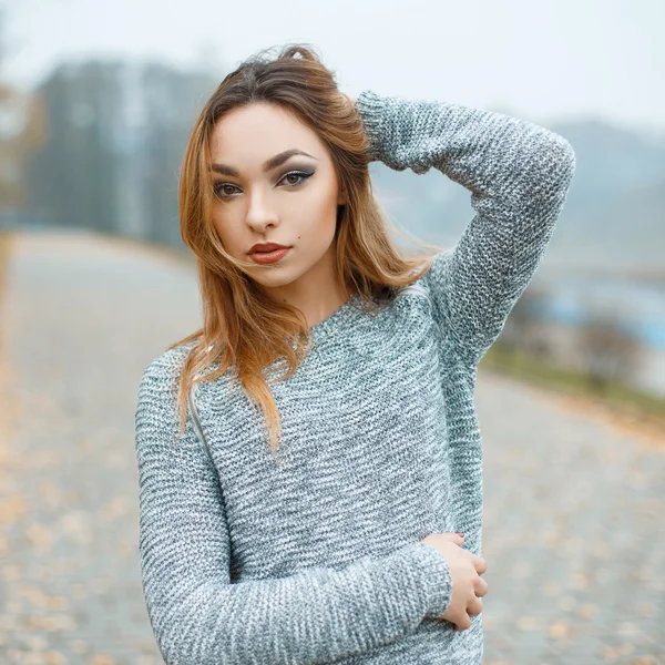 Beautiful girl in a knitted sweater against the backdrop of autumn park — Stock Fotó