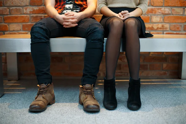 Fashionable stylish couple sitting on the bench. Legs close-up — 图库照片