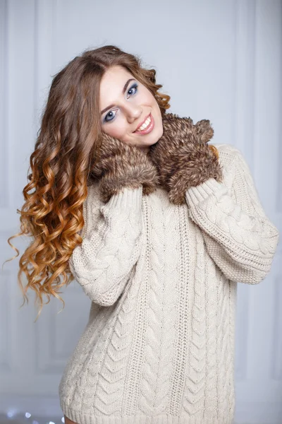 Schöne fröhliche Mädchen mit erstaunlichem Lächeln in einem warmen Pullover und Fäustlingen — Stockfoto