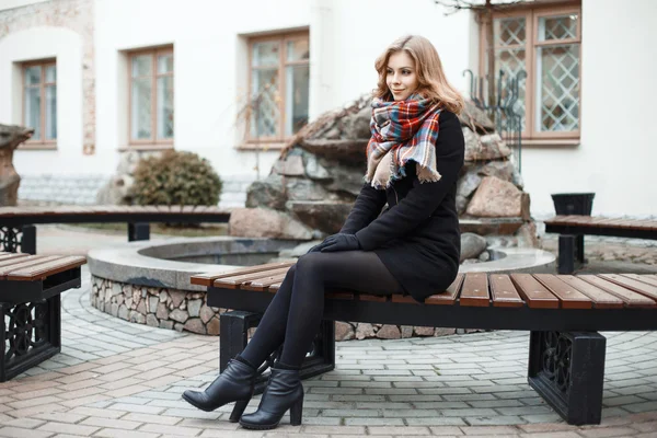 Jeune femme élégante se détendre sur un banc — Photo
