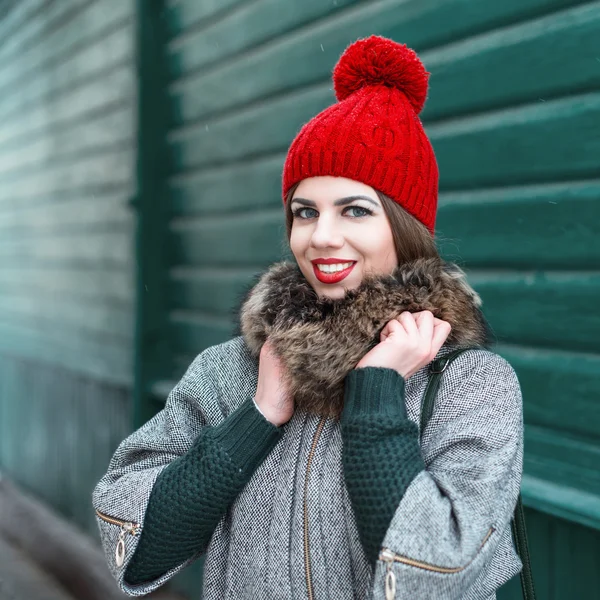 Stylish girl in vintage winter knitted clothes on a background of an old green wooden house — ストック写真