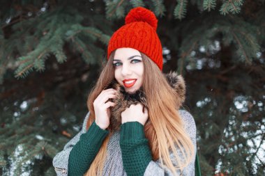 Beautiful young girl with a cute smile in winter fashionable clothes