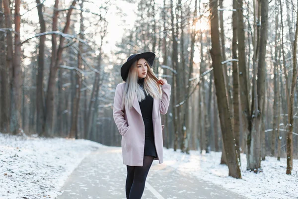Menina bonita nova em um chapéu elegante e casaco andando no parque de inverno — Fotografia de Stock