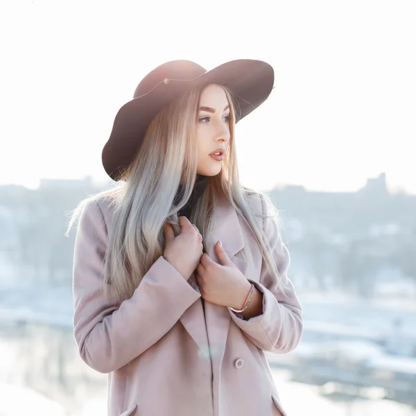 Portrait of a beautiful young girl in a stylish hat and coat on a sunny winter day — 图库照片