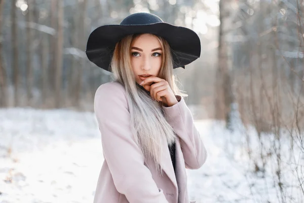 Retrato de uma bela jovem mulher em um chapéu preto e um casaco vintage no dia de inverno fresco . — Fotografia de Stock