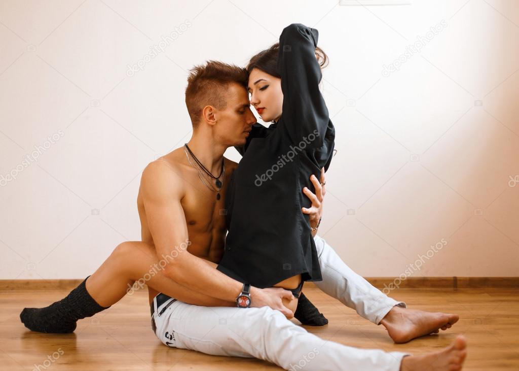 Young Caucasian couple lying on the floor and hugging.