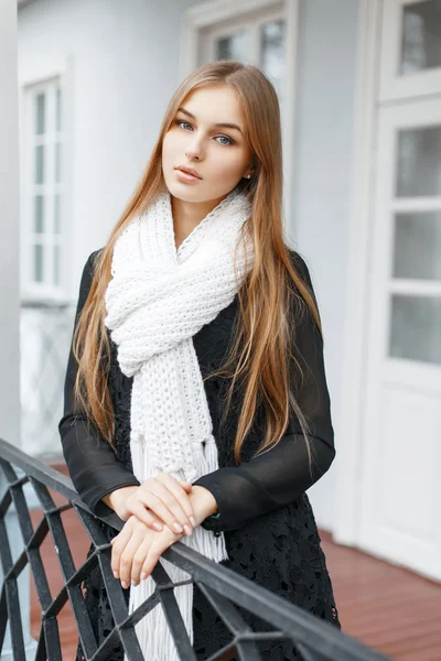 Beautiful girl in a white knitted scarf and a black fashionable dress — Zdjęcie stockowe