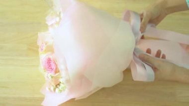 Buket, el etrafında pembe gül buketi çiçekçi uygulamakla şerit düzenleme