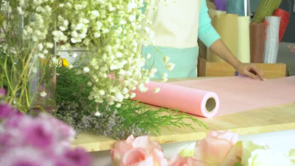 Квітковий магазин, рука флориста розгортається і ріже пекучий папір — стокове відео