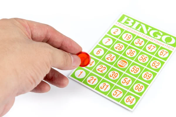 Hand putting first chip to bingo game card — Stock Photo, Image