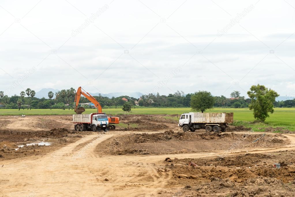 Excavator machine moves with raised bucket on construction site