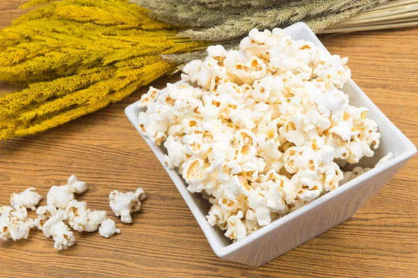 Popcorn v misce čtvercového tvaru s plodinou, žito vedle — Stock fotografie