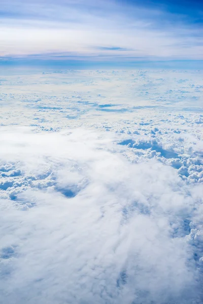 Het uitzicht vanuit het vliegtuig boven de wolk en de hemel Stockfoto