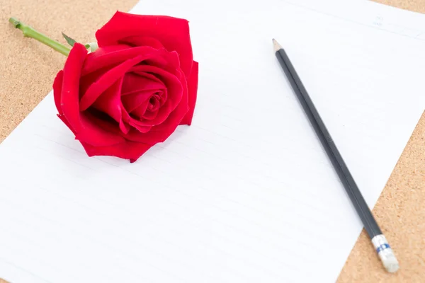 Papelão, cortiça com papel de nota com lápis e rosa ao lado — Fotografia de Stock