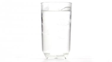 Cam soğuk su ve buz erime küp ile dolu. Aşağı cam dışında zaman atlamalı akan su dop